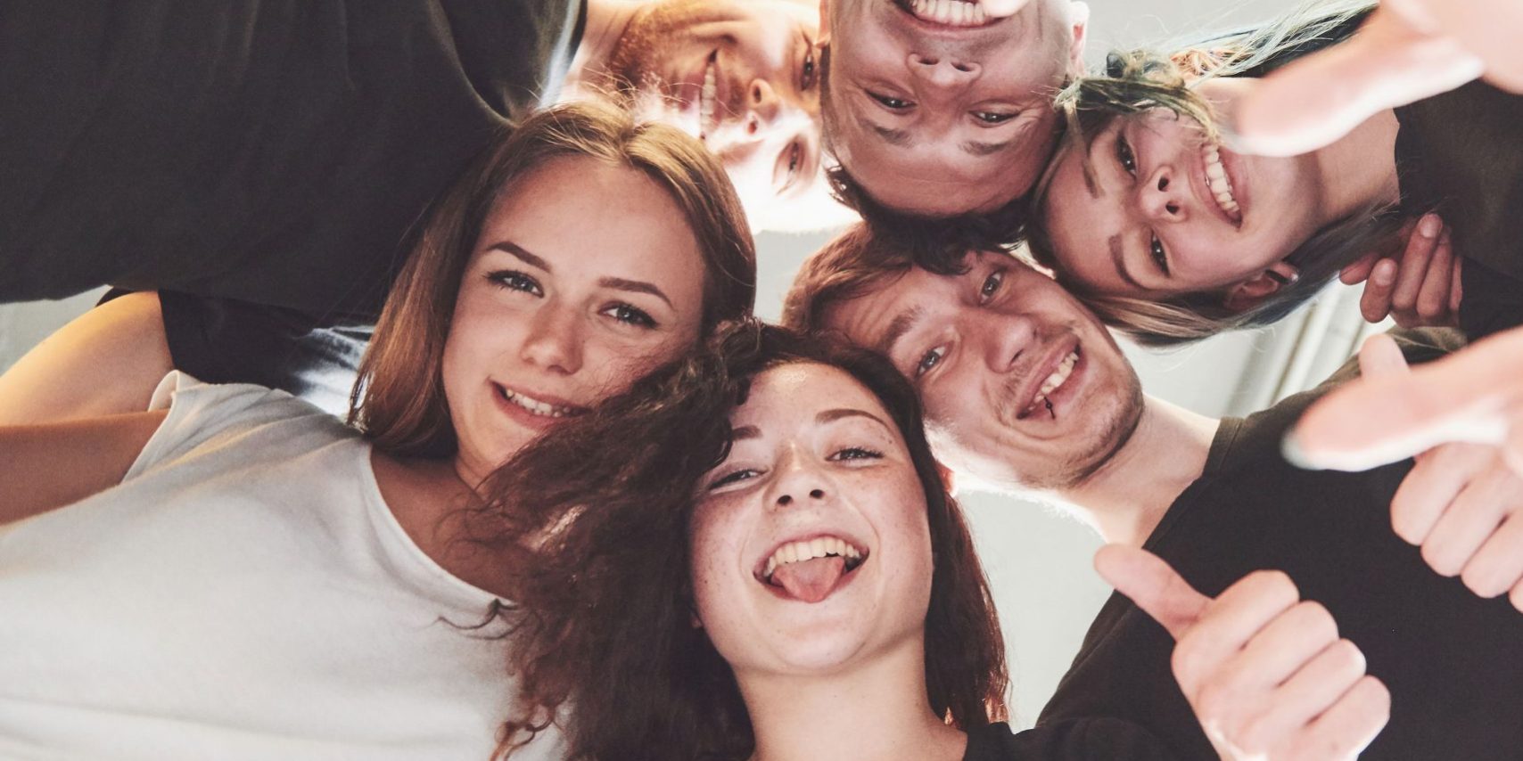 Happy group of friends with their hands together in the middle